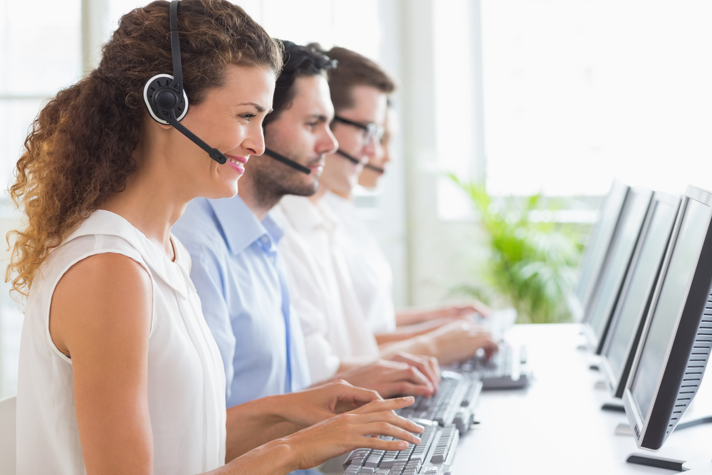 Customer service representatives working at desk in office Customer service representatives working at desk in office