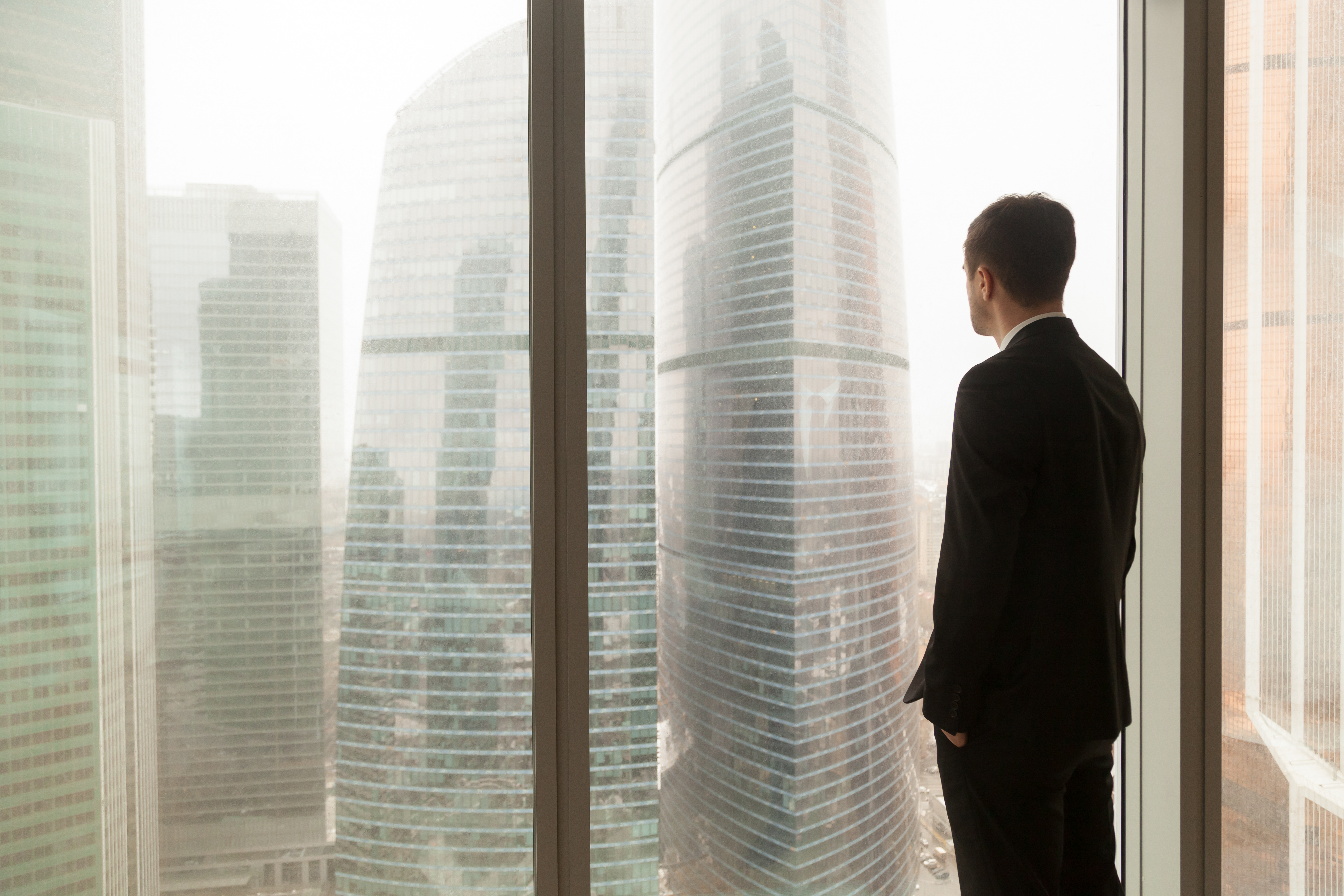 company-official-looking-through-window-office